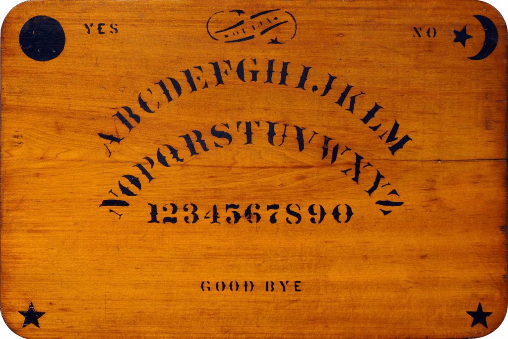 Vintage wooden Ouija board with black stenciled letters, numbers, and symbols used for spirit communication and paranormal inquiry.