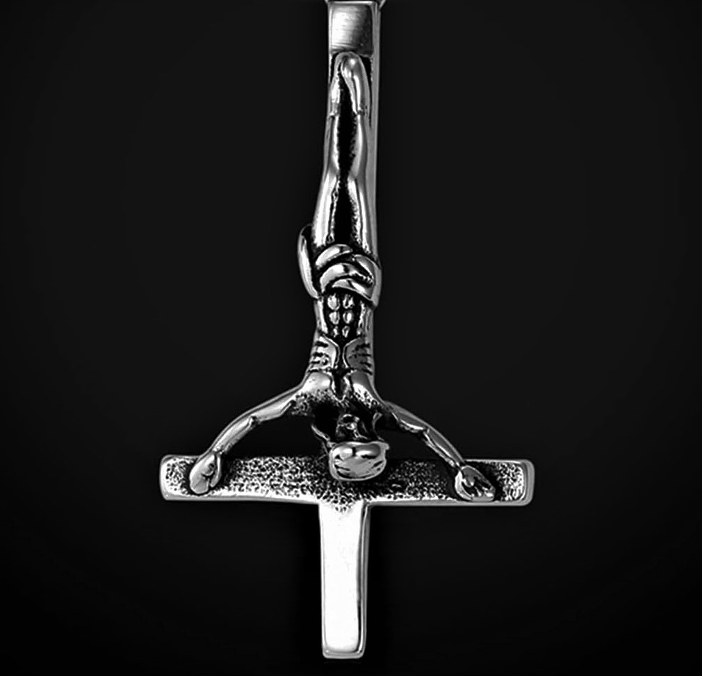 Silver upside-down crucifix pendant featuring a muscular figure hanging by clasped hands – gothic and symbolic jewelry design.